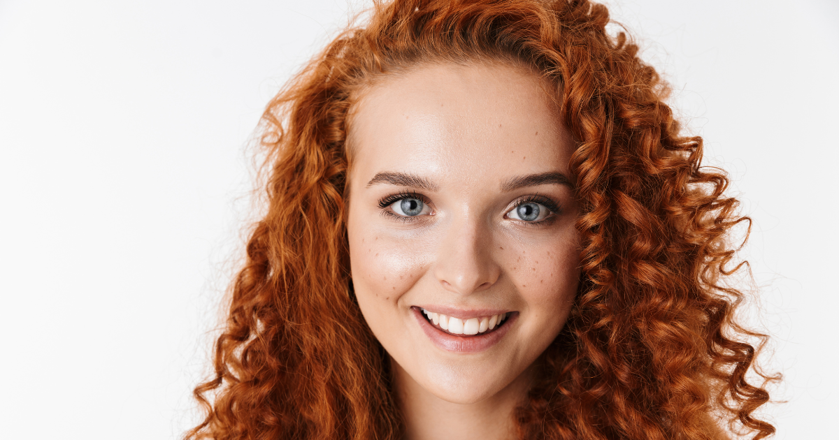 woman smiling with red hair asking if laser hair removal works for red hair